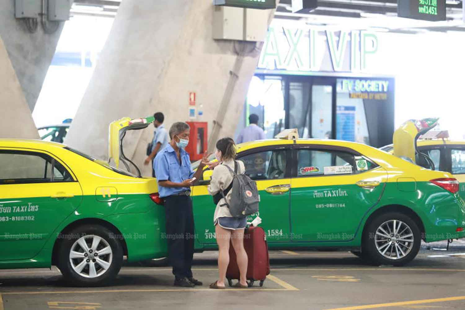 A taxi driver with a potential passenger at Suvarnabhumi airport in Samut Prakan province. (Photo: Somchai Poomlard)