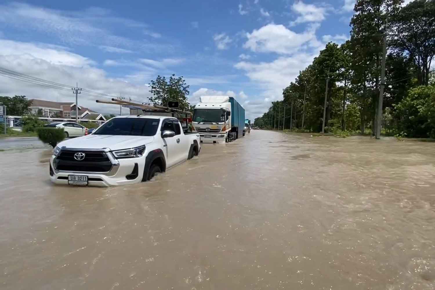 Many vehicles stalled on the heavily-flooded Mittraphap highway near kilometre marker 302 in Khon Kaen's Ban Phai district on Wednesday. Large water pumps were being used to drain the water into the Chi river. (Photo: Chakrapan Natanri)