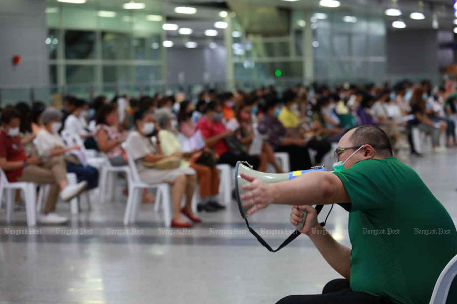 A supervisor guides Covid-19 vaccine recipients at Bang Sue Grand Station in Bangkok in July. (Photo: Apichart Jinakul)