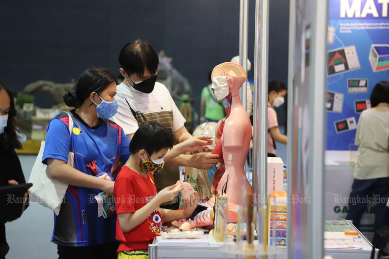 People wearing face masks visit the National Science and Technology Fair 2022. The event is being held at the IMPACT Arena, Exhibition and Convention Center, Muang Thong Thani, in Nonthaburi province until Sunday. (Photo: Wichan Charoenkiatpakul)