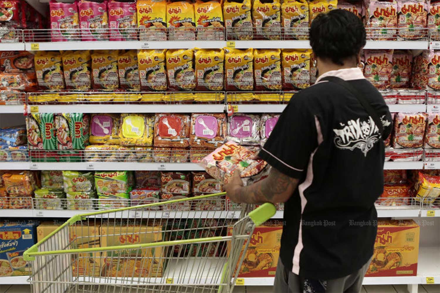 A consumer examines a variety of instant noodles on a shelf at a supermarket in Bangkok. (File photo)