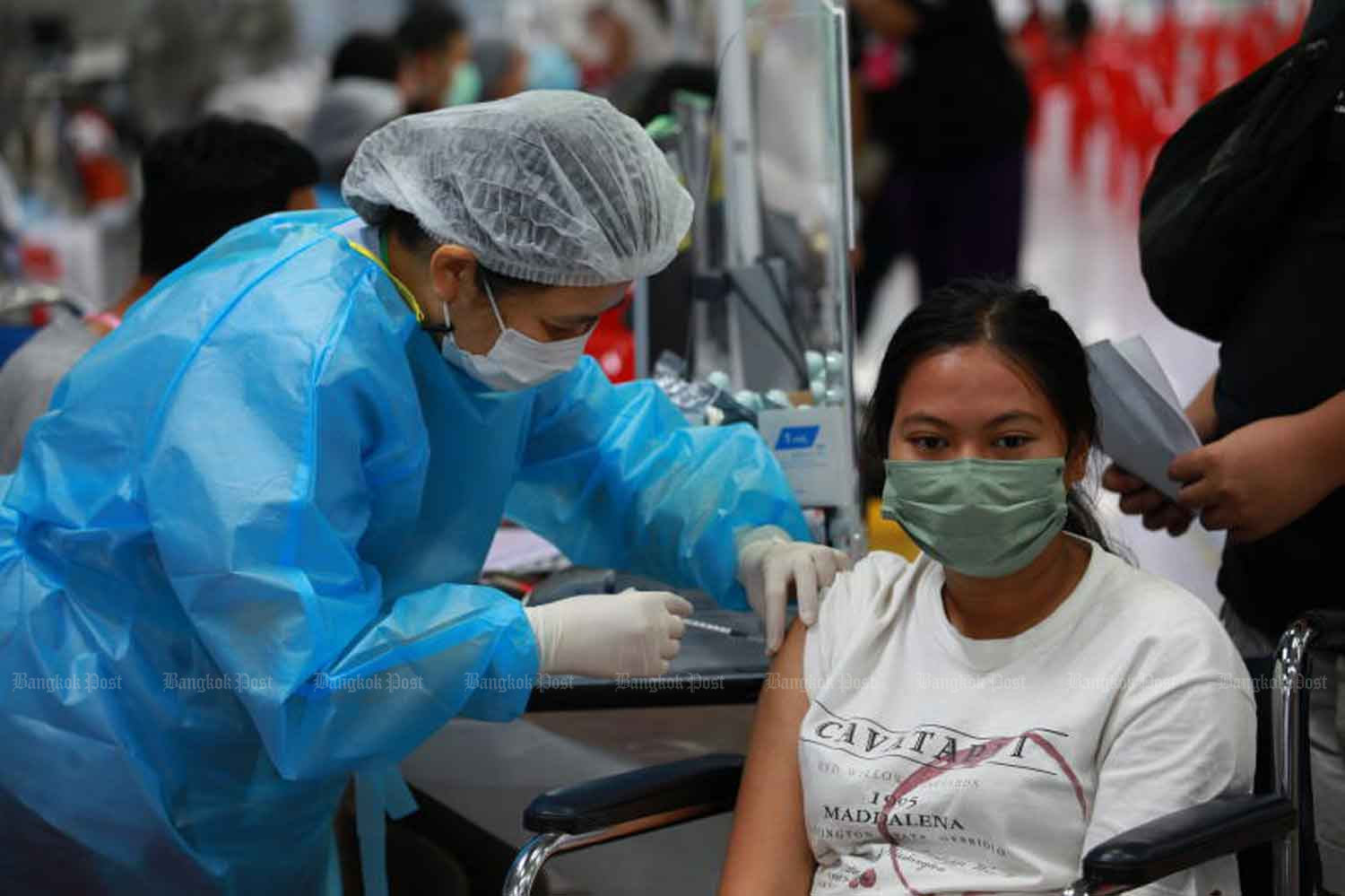 A health worker vaccinates a woman against Covid-19 at the Bang Sue Grand Station in Bangkok in August. (Photo: Apichart Jinakul)