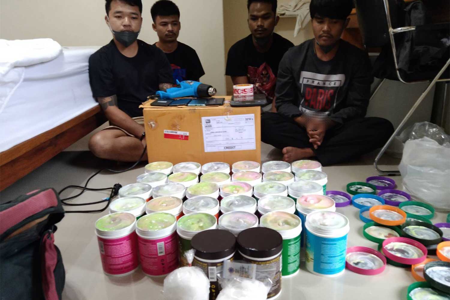 The four suspects, along with jars labelled hair treatment cream but containing crystal methamphetamine, during their arrest at a resort in Nong Khai province on Tuesday.(Photo supplied: Wassayos Ngamkham)