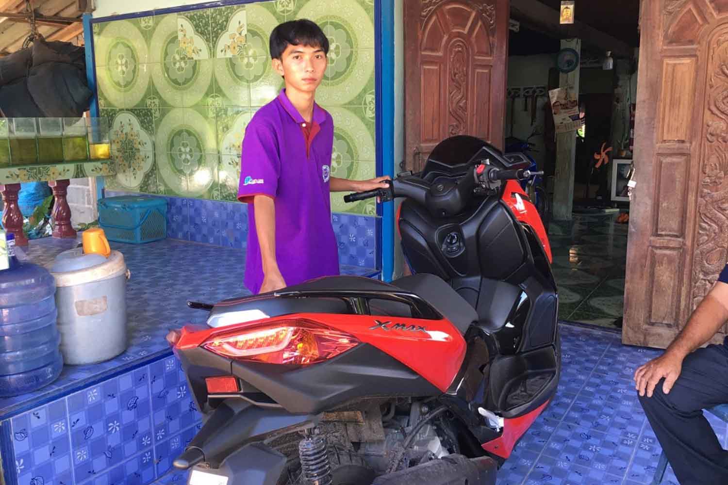 Kengcharoen Thamhon, the Mathayom 6 student, with his motorcycle. (Pattanapong Sripiachai)