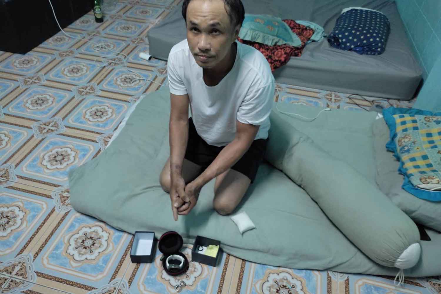 Pongdet Lewtrakul, 41, points the luxury watch and diamond ring stolen from the scene of a road accident, in his room in tambon Bang Phun of Muang district, Pathum Thani, on Wednesday night. (Photo supplied)