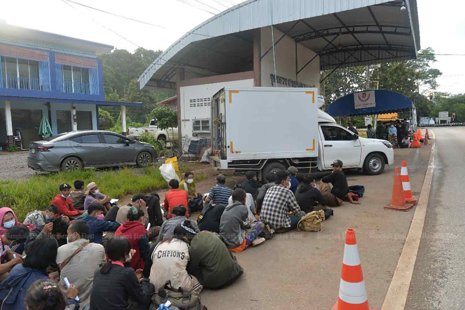 Illegal border crossers from Myanmar rest by a roadside after being caught in Thong Pha Phum district, Kanchanaburi, on Wednesday morning. (Photo supplied