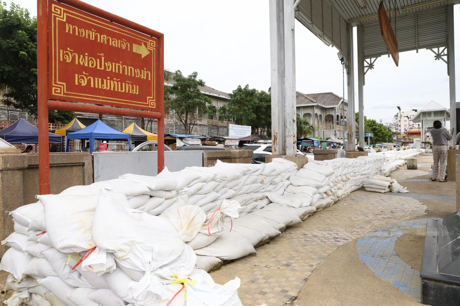 In Nonthaburi, sandbags are stacked up to form a long embankment against an overflowing Chao Phraya River outside the old town hall building. (Photo: Wichan Charoenkiatpakul)