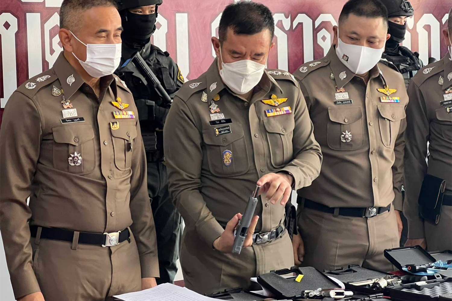 Pol Lt Gen Piya Tawichai, Provincial Police Region 5 commissioner, examines guns seized from a 21-year-old university student at his condominium room in Chiang Mai. (Photo: Panumet Tanraksa)