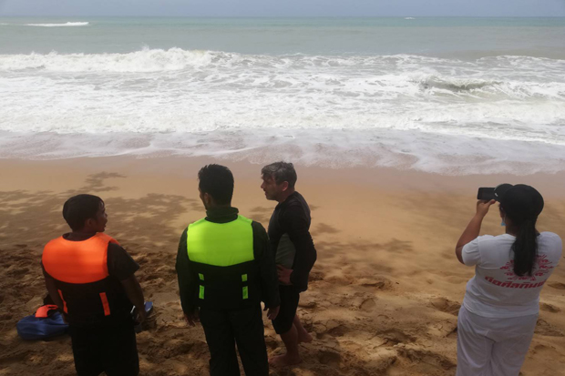 Divers and volunteers stand on a beach during their search for Japanese tourist Satoshi Sato, who went missing after going swimming at Khao Lak in Takua Pa district of Phangnga on Saturday. His body was later recovered. (Photo: Achadtaya Chuenniran)