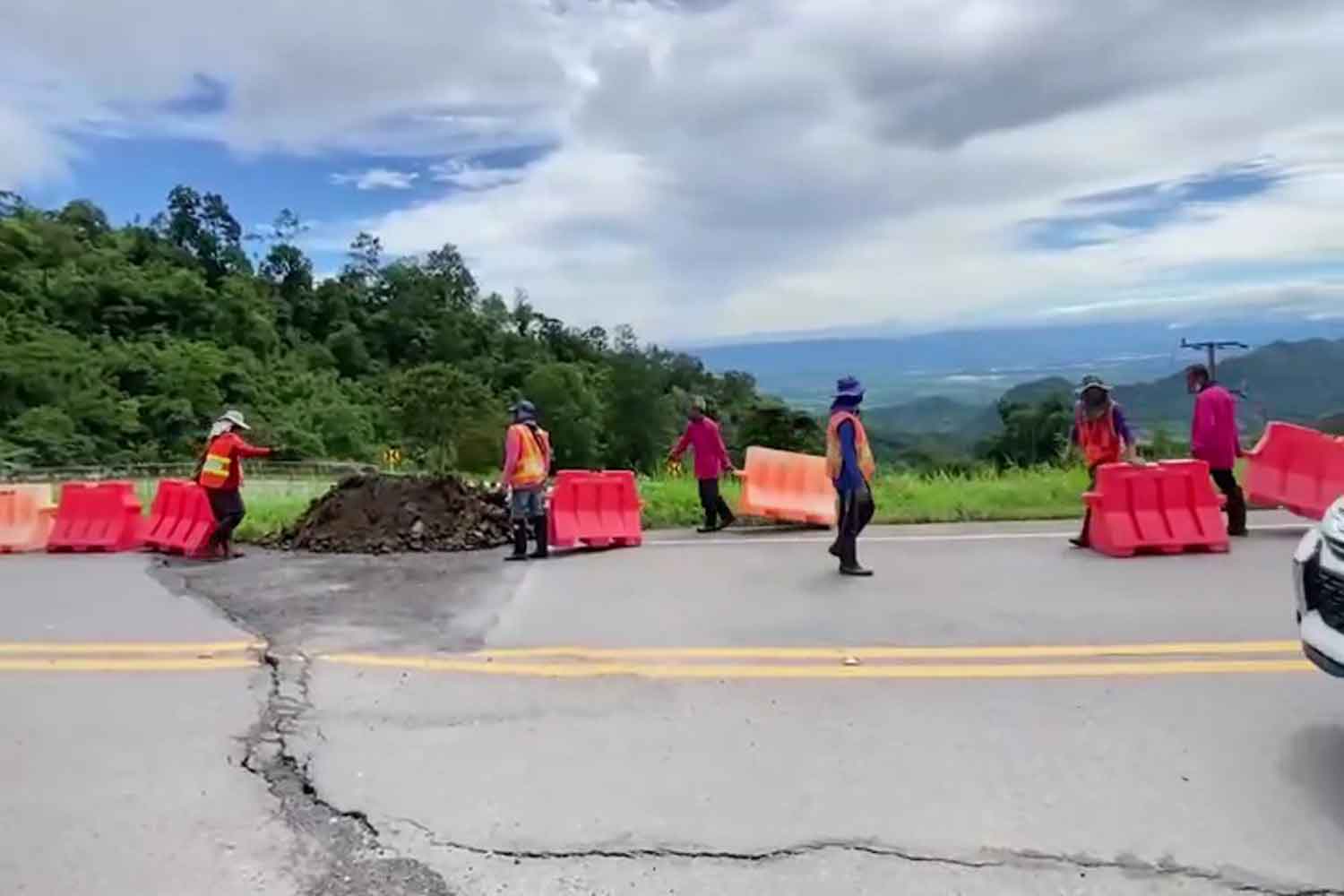 Highway workers are repairing the cracked Highway 2331 to the Phu Thap Boek mountain in Lom Kao district, Phetchabun, on Tuesday. (Photo: Soonthorn Kongvarakom)