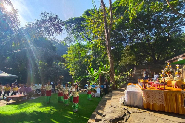 WELCOMING VISITORS: A group performs a traditional dance on Saturday in front of Tham Luang cave complex in Chiang Rai as part of a merit-making ceremony before the park opens for public visits on Sunday.