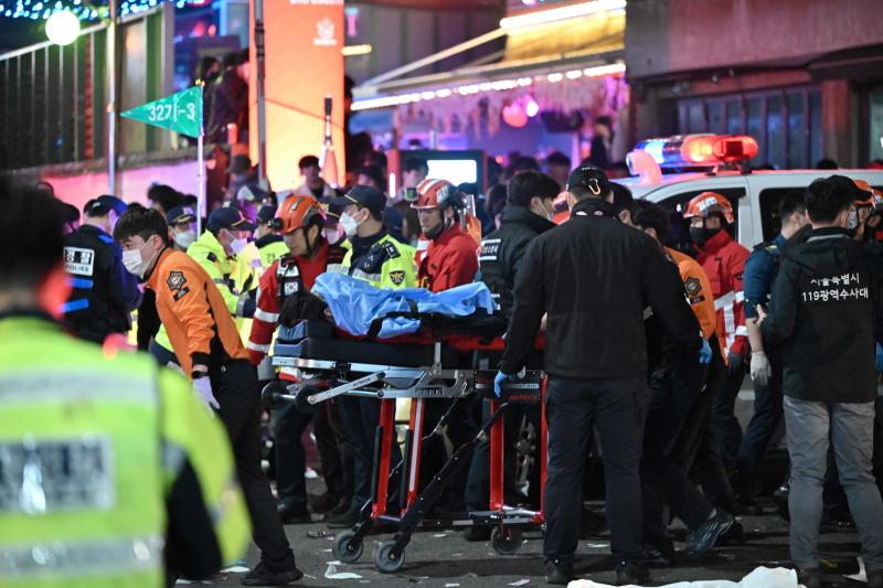 A person, believed to have suffered from cardiac arrest, is transported on a stretcher in the popular nightlife district of Itaewon in Seoul on Saturday. (Photo: AFP)