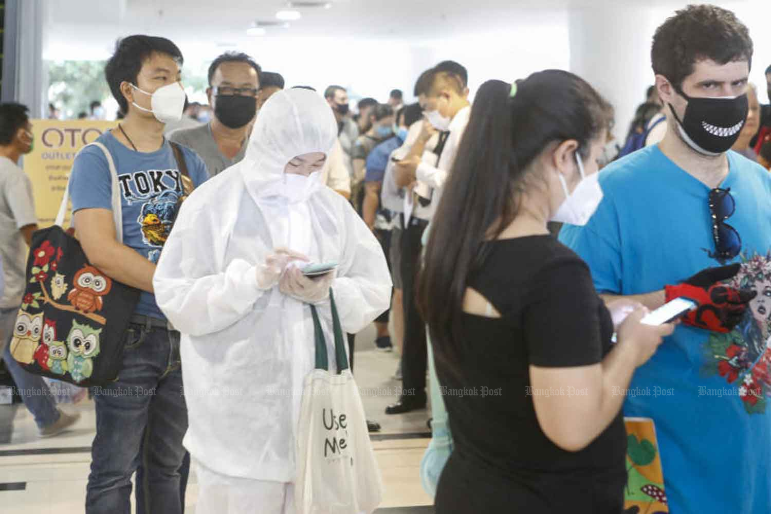 A foreign visitor wears what appears to be a hazmat suit at the immigration bureau office at the Government Complex in Bangkok in 2020. A large number of foreign nationals are turning up to ask for visa extensions after the Covid-19 pandemic disrupted their travel plans. (Photo: Pattarapong Chatpattarasill)