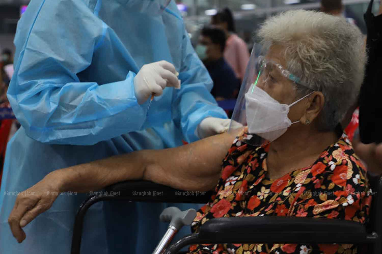 A nurse vaccinates an elderly woman against Covid-19 at Bang Sue Grand Station in Bangkok in July. Elderly people will be among the first groups of Covid vaccine recipients next year. (Photo: Wichan Charoenkiatpakul)