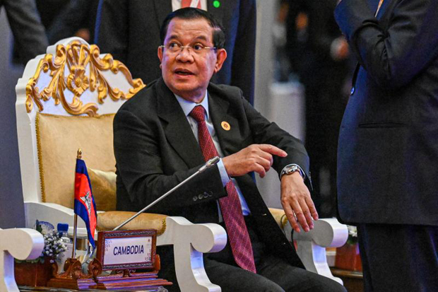 Cambodian Prime Minister Hun Sen shows a watch made in Cambodia and offered as gift to leaders attending the Asean summits at Sokha hotel in Phnom Penh on Thursday. (AFP photo)