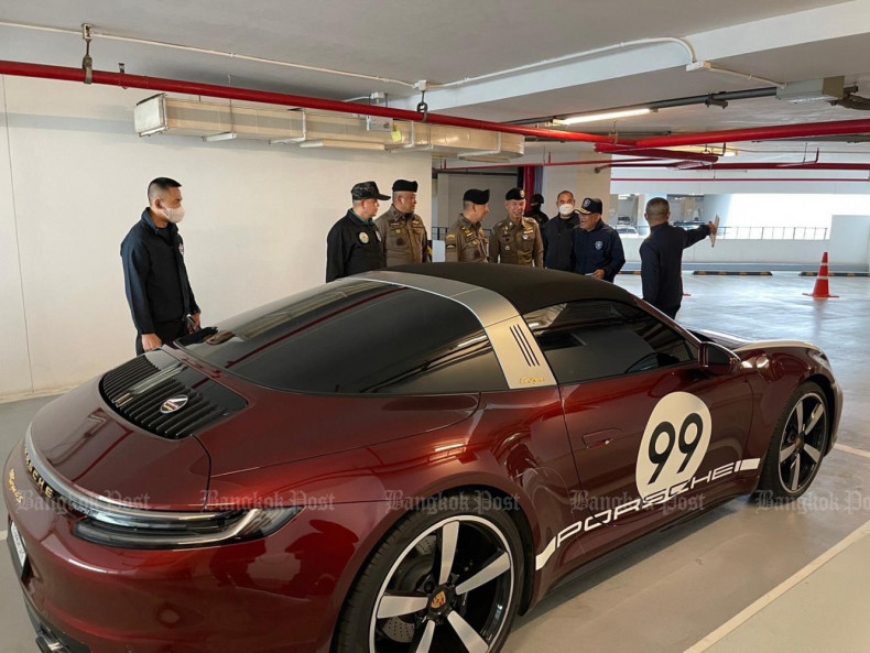 Police seize a Porsche and other luxury cars for examination during raids in Bangkok and Samut Prakan on Tuesday. (Police photo)