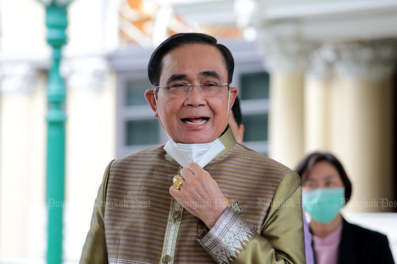 Prime Minister Prayut Chan-o-cha appears to be in a good mood as he walks past a group of reporters after the weekly cabinet meeting at Government House on Tuesday. (Photo: Chanat Katanyu)