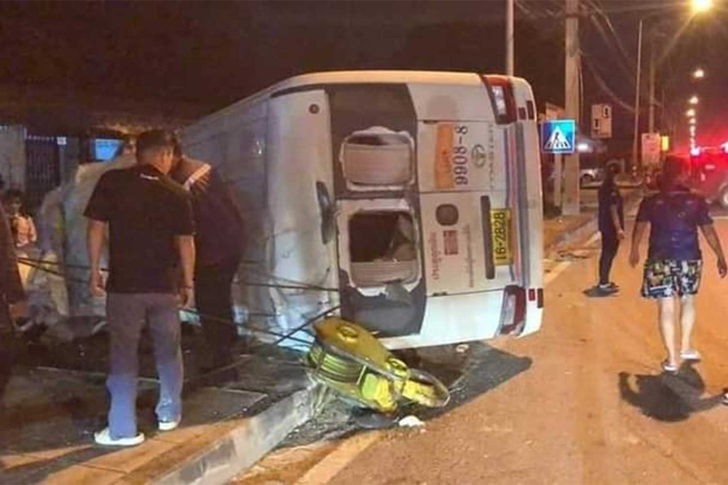 Rescue workers help the injured passengers of the overturned minibus, which was hit by the hanging hook of a mobile crane emerging from a side street in Ban Bung district of Chon Buri province on Wednesday night. (Photo: Accident-Rescue News, Nong Mai Daeng Chon Buri Facebook)