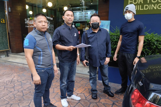 Crime Suppression Division police serve Natthawat Warodommakorn (second right) with an arrest warrant issued by the court outside a condominium on Thursday. He was detained and sent to the provincial court in Kanchanaburi province. (Photo: Crime Suppression Division)