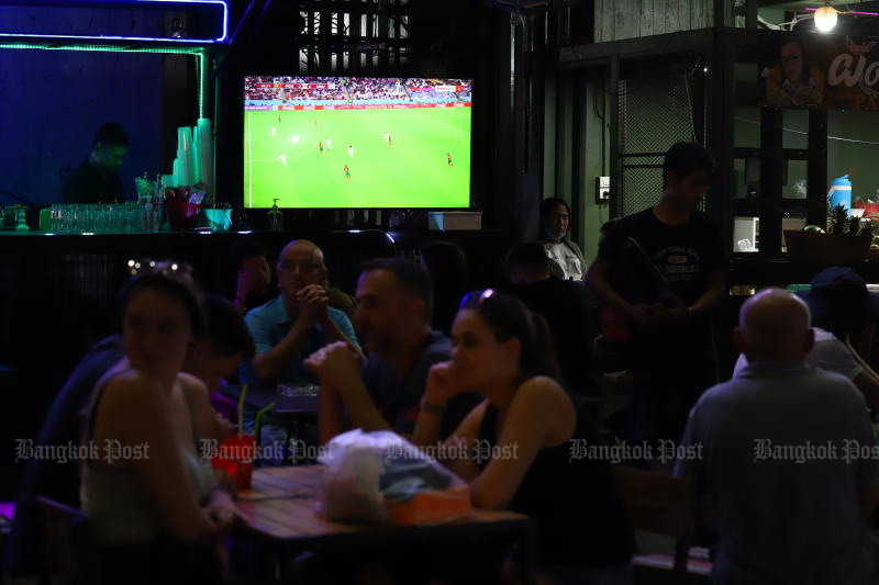 Diners watch a televised broadcast of a World Cup match on Khao San Road, Bangkok, on Nov 29, 2022. (Photo: Nutthawat Wicheanbut)