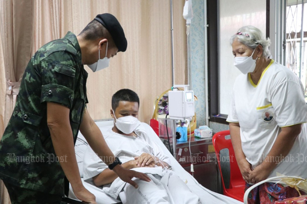 Deputy Army Region 4 commander Maj Gen Paisal Nusang visits a student at an unknown hospital in Narathiwat, with a parent at his side. The boy became ill after an army training course on Monday. (Photo: Abdullah Benjakat)