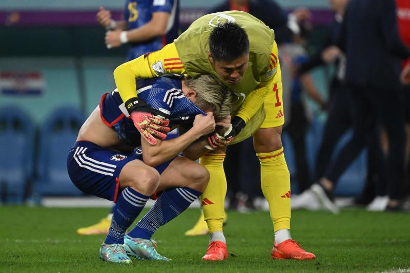 Japan's forward Takuma Asano (left) is consoled by Japan's goalkeeper Eiji Kawashima after they lost the Qatar 2022 World Cup round of 16 football match between Japan and Croatia at the Al-Janoub Stadium in Al-Wakrah, south of Doha, on Monday. (AFP photo)