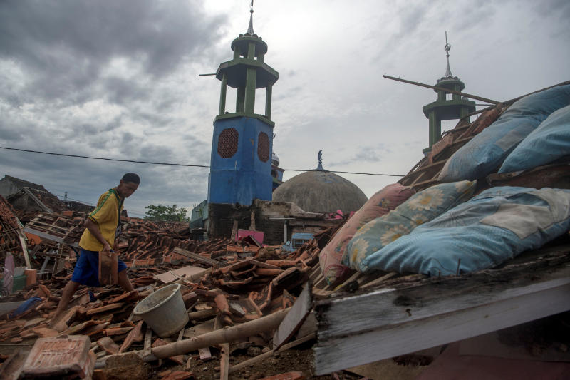 A man walks among rubble as he collects roof tiles from a collapsed house after Monday's earthquake in Cianjur, West Java province, Indonesia, on Nov 25, 2022.(Photo: Reuters)