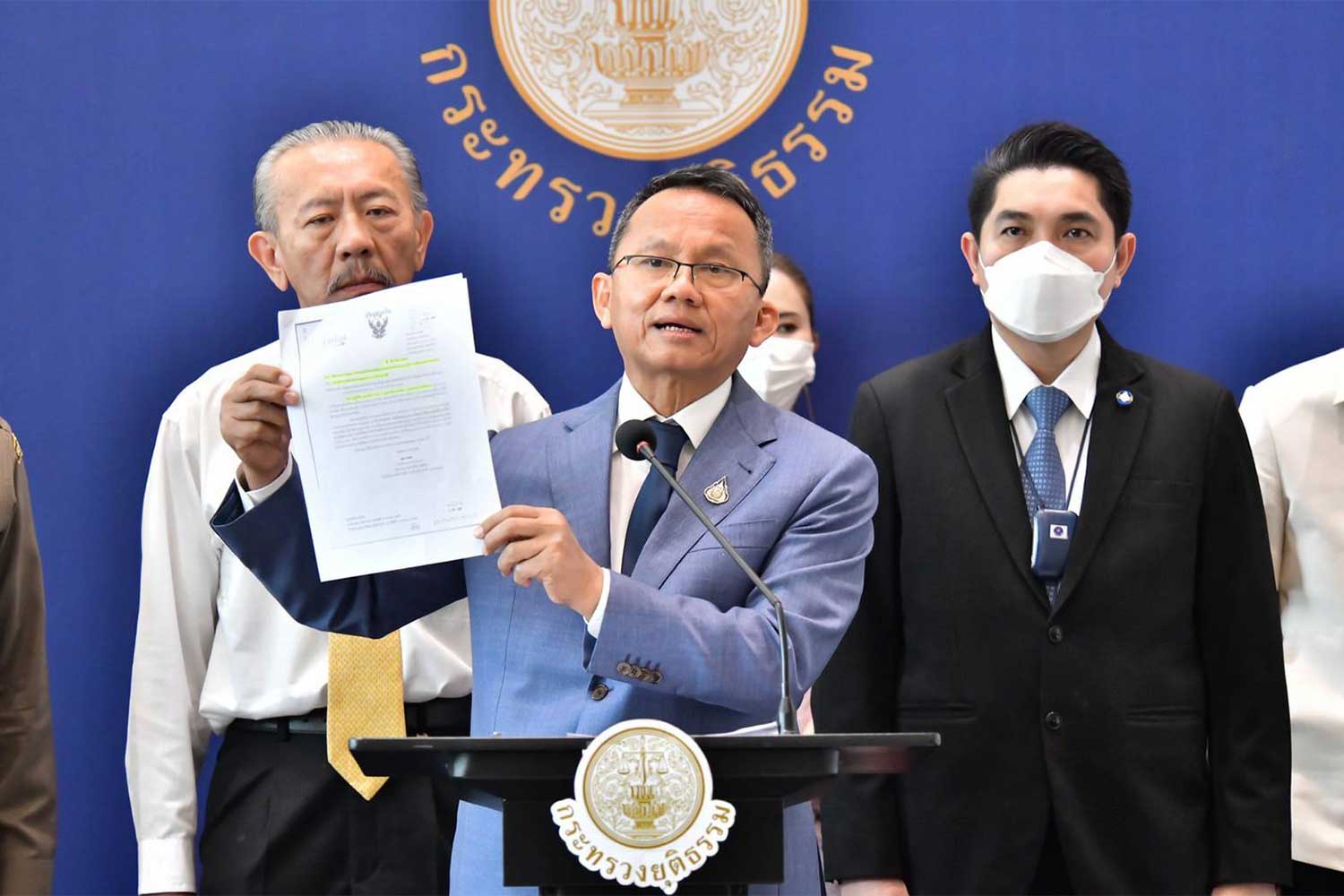 Justice Minister Somsak Thepsuthin shows a document about the seizure of assets from alleged Triad boss Chaiyanat "Tuhao" Kornchayanant, at a press conference on Friday. He is shown with former politician Chuvit Kamolvisit, left, and justice minister secretary Thanakit Jitareerat, right. (Photo: Ministry of Justice, Thailand Facebook)