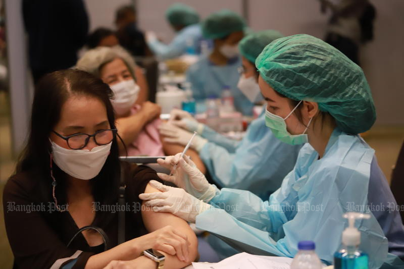 Nurses administer booster shots at Siam Paragon shopping mall in Bangkok on Tuesday. The Department of Disease Control and private hospitals are providing booster shots at Siam Paragon from Dec 20-26. (Photo: Somchai Poomlard)