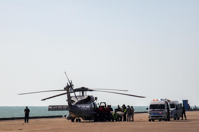 A helicopter carries an injured sailor and a body of a Royal Thai Navy sailor to Bang Saphan Hospital on Wednesday. They were crewmen of HTMS Sukhothai which was capsized on Sunday night. (Reuters photo)