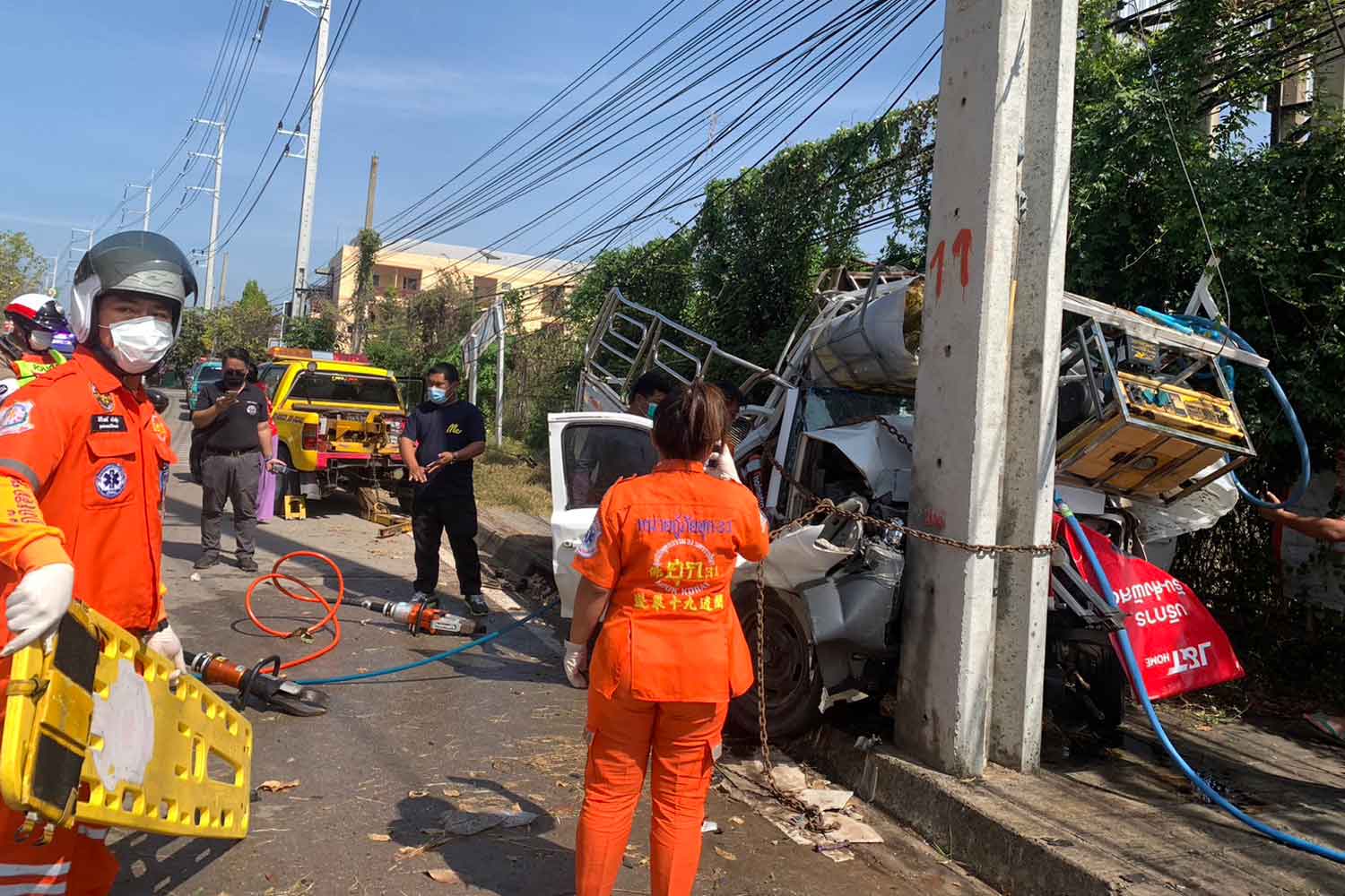 Rescue workers attend the deadly crash scene after a pickup truck smashed into a power pole in Muang district, Nakhon Ratchasima, on Saturday. A passenger was killed and the driver was seriously injured. Police assumed the driver dozed off when the accident happened at 11.24am. (Photo: Prasit Tangprasert)