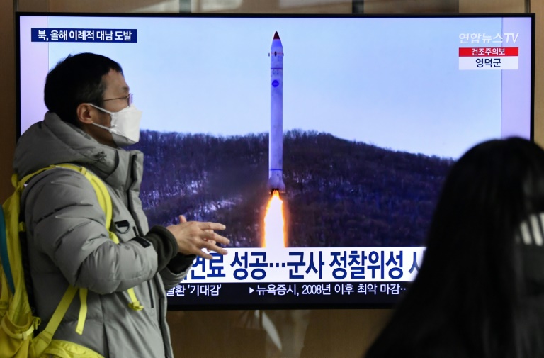 A man walks past a television screen showing a news broadcast with file footage of a North Korean missile test, at a railway station in Seoul on December 31, 2022 after North Korea fired three short-range ballistic missiles according to South Korea's military.