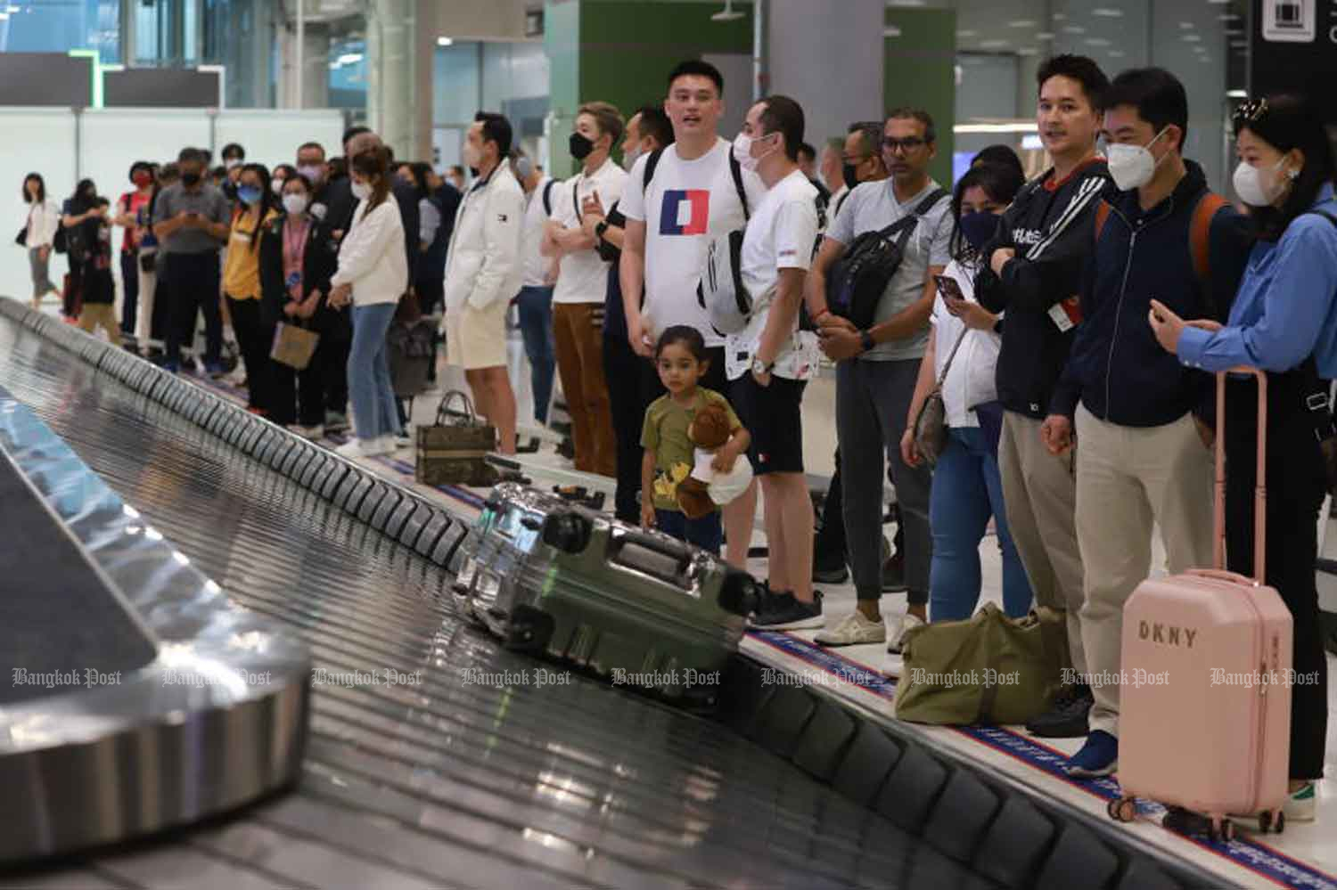 Travellers wait for their luggage at Suvarnabhumi airport in Samut Prakan on Dec 28. (Photo: Somchai Poomlard)