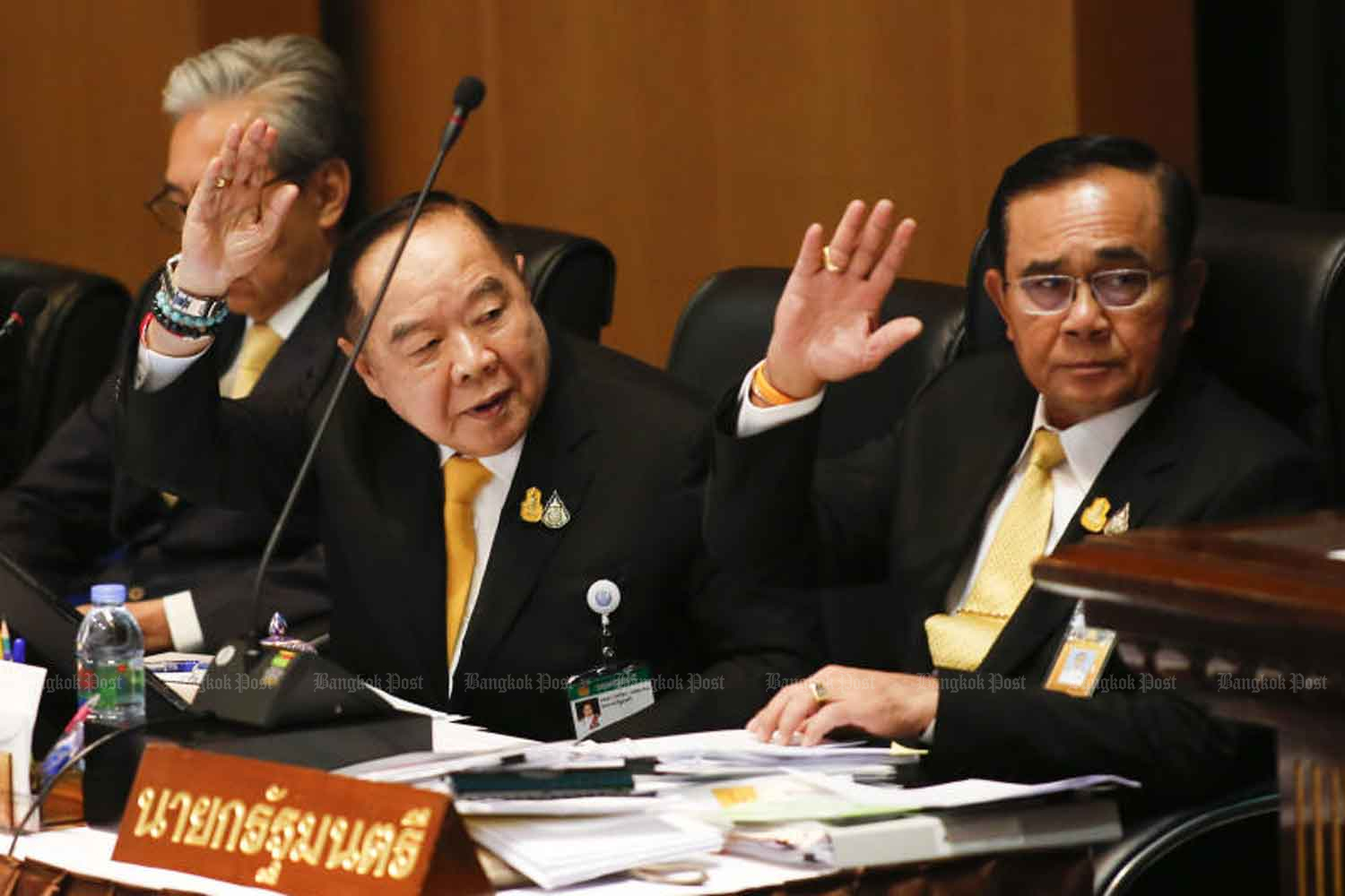 Prime Minister Prayut Chan-ocha, right, and his deputy Gen Prawit Wongsuwon raise their hands to ask for permission to address the paliament chamber and debate the government’s policy manifesto in July 2019. (Photo: Pattarapong Chatpattarasill)