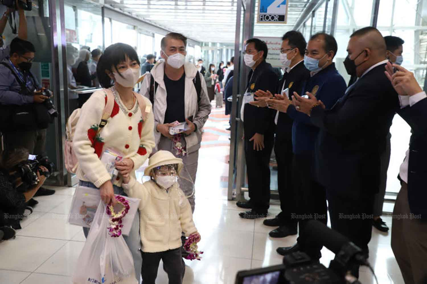 Thai officials warmly applaud and offer garlands to welcome visitors from China at Suvarnabhumi airport in Samut Prakan province on Monday. (Photo: Varuthh Hirunyatheb)