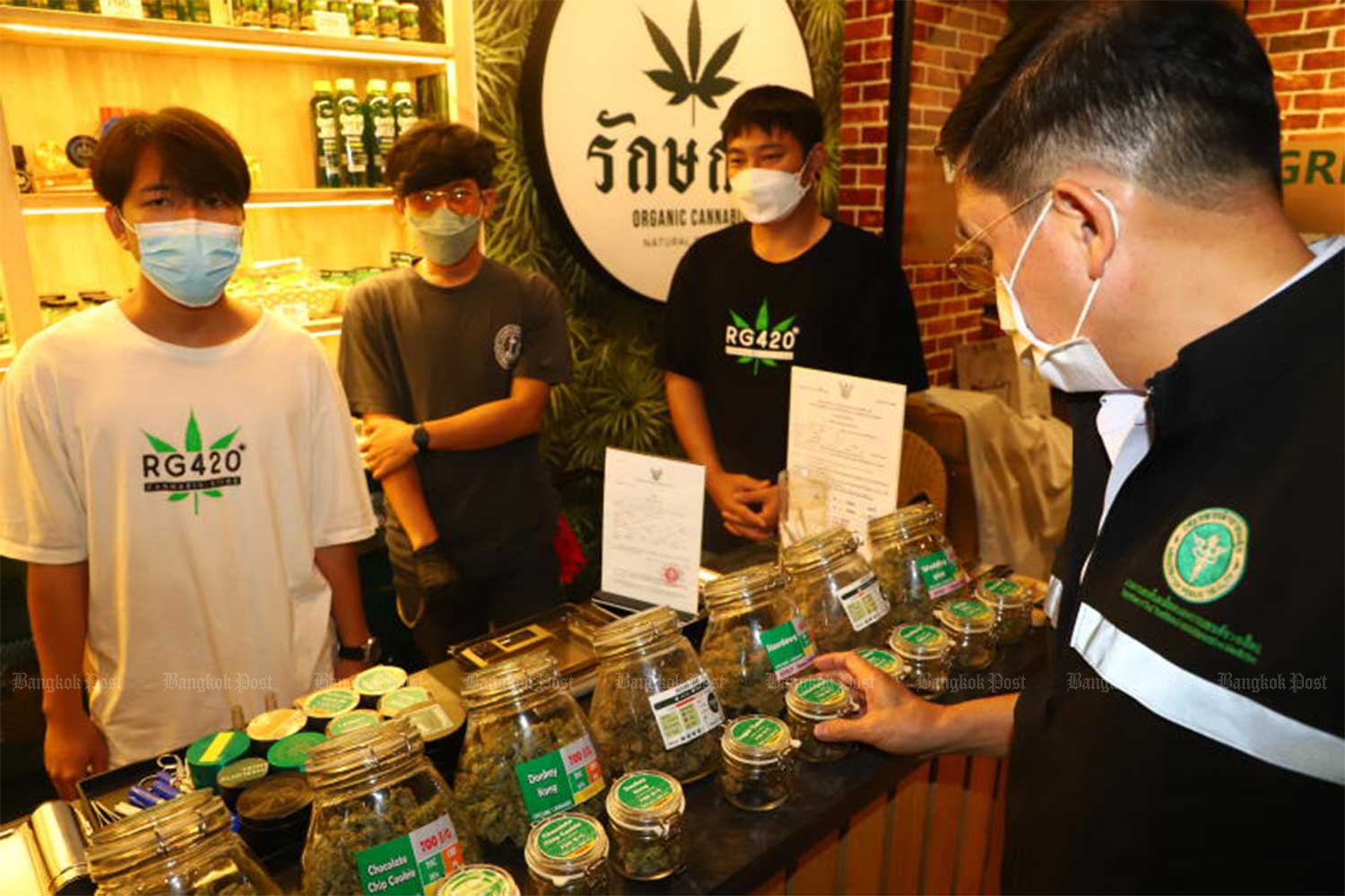 An official from the Department for the Development of Thai Traditional and Alternative Medicine inspects cannabis products at a shop on Khao San Road in Bangkok in November. (File photo: Nutthawat Wicheanbut)