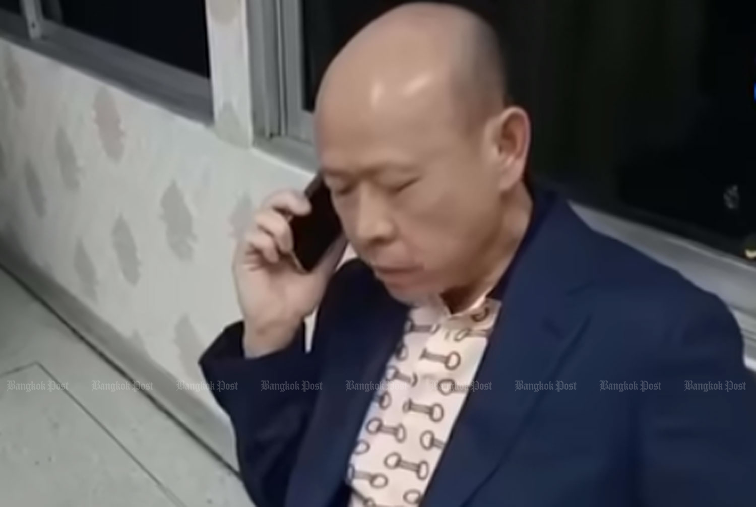 Suthat Siwapiromrat, who declined to take a breath test at the scene of an accident involving his Bentley, is seen making a phone call shortly afterward On Jan 8. (Image from TV Channel 8 video)