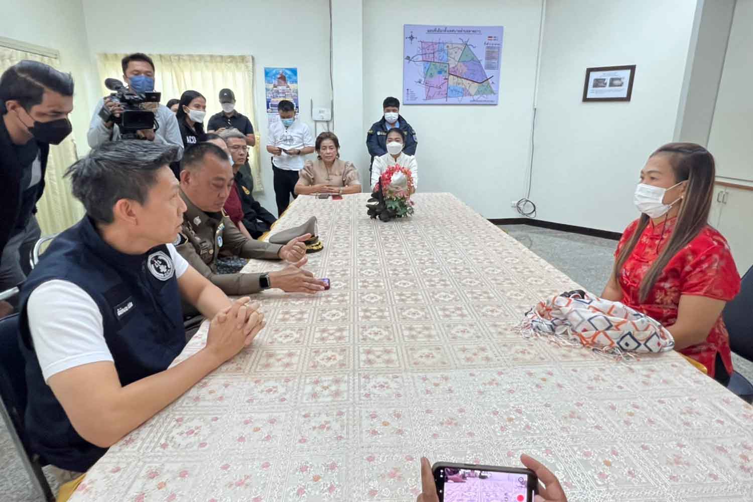 Patchara Prasithikam, right, a financial clerk at the accounting office of the Tambon Lat Yao Municipality in Nakhon Sawan, gives her statement to police officers on Thursday. She was arrested for allegedly embezzling over 15.8 million baht from her office's bank account. (Photo supplied)