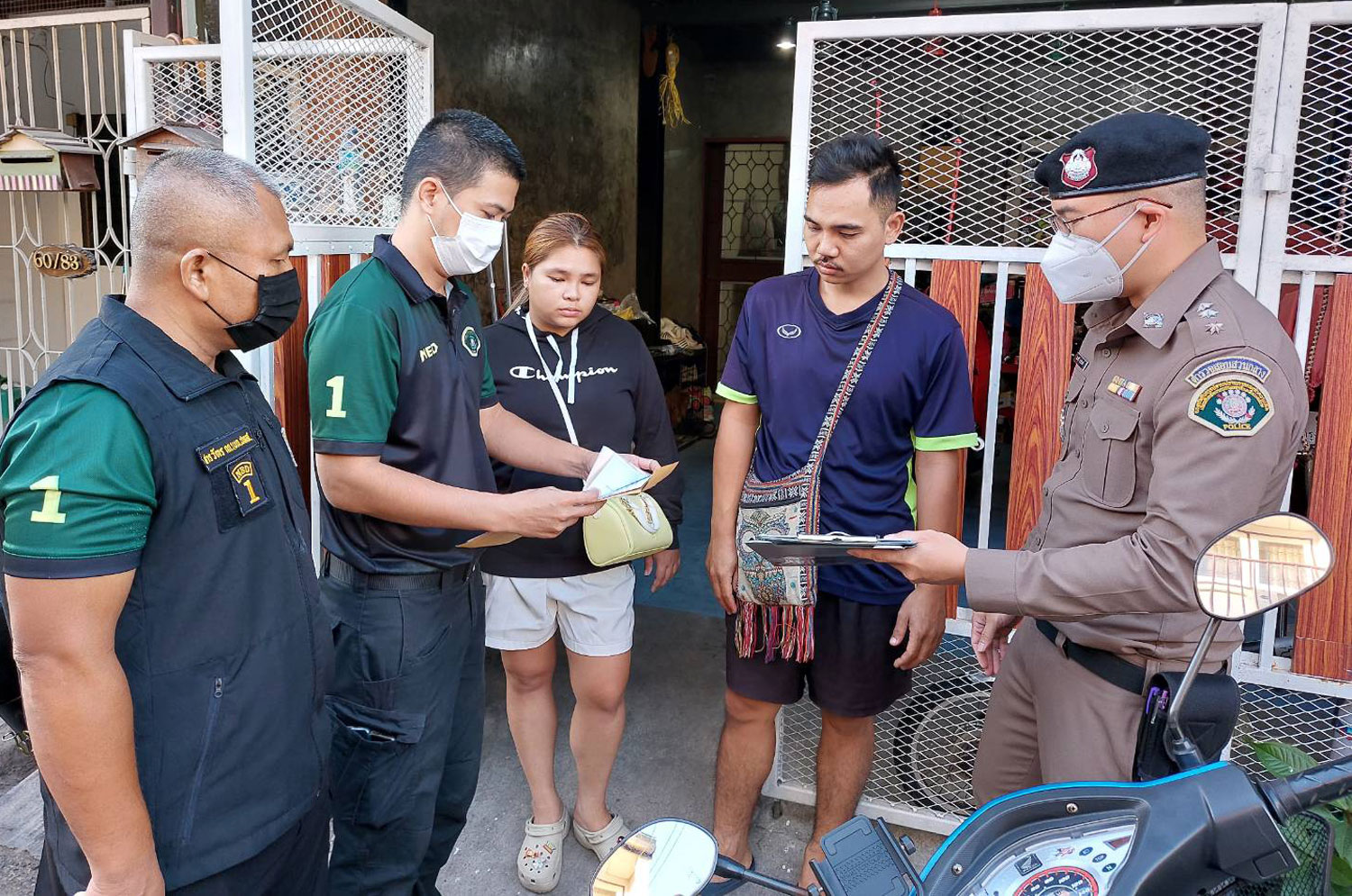 Officers question Phatcharapha Prasongdee and her husband Sitthichai Boonlai at a house in the Jorakhae Bua area of Lat Phrao district in Bangkok after arresting them on charges of illegal trading in wildlife. (Photo supplied/Wassayos Ngamkham)