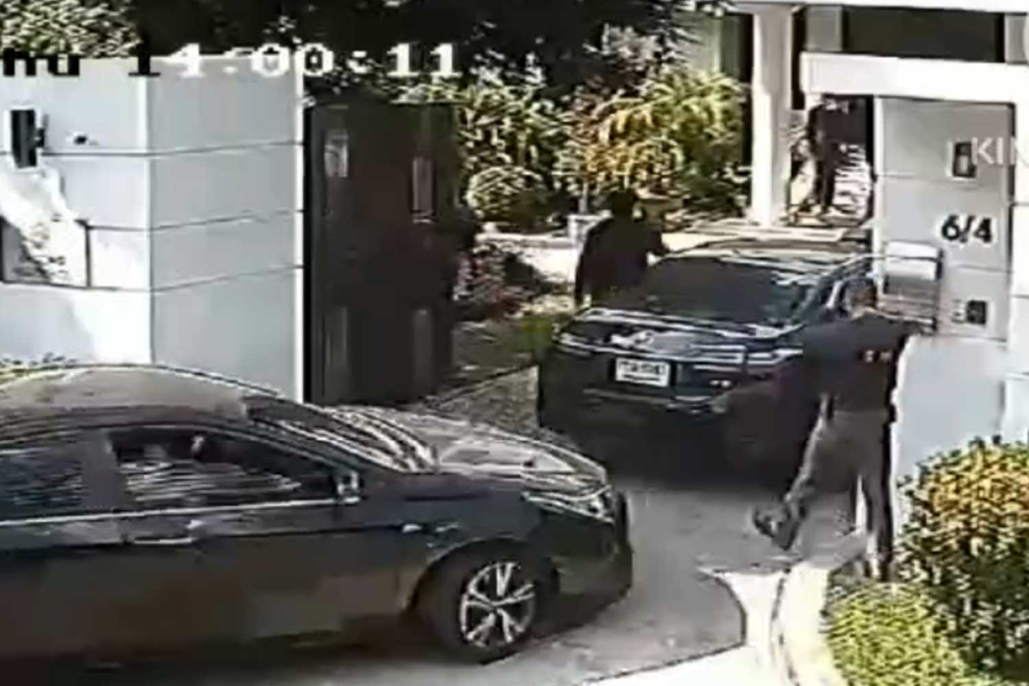 Cars carrying police and DSI officials enter the residence of a former consul-general of the Republic of Nauru in Sathon district of Bangkok on Dec 22, where 11 Chinese nationals suspected of criminal activity were hiding. (Capture from video: Chuvit Kamolvisit Facebook page)