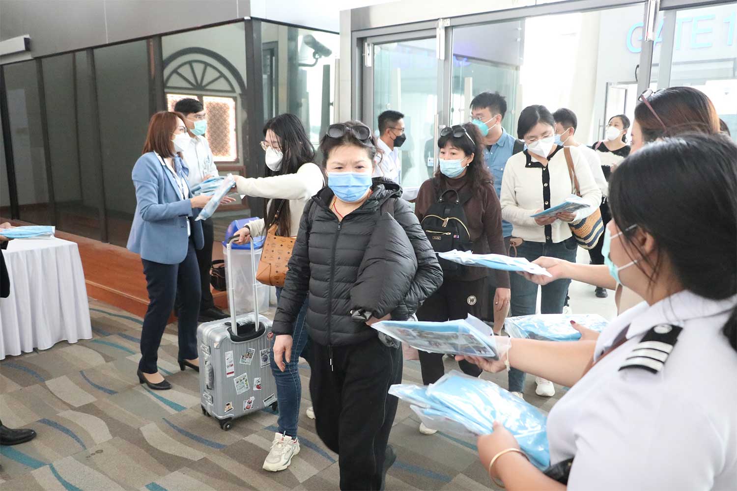 Airport staff greet and give souvenirs to passengers of China Eastern Airlines flight MU2813 around 5pm on Thursday. (Photo: Achadthaya Chuenniran)