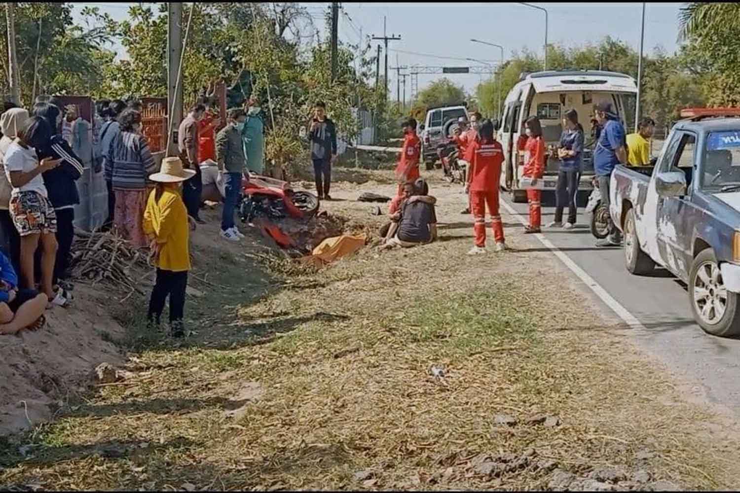 Rescue workers and onlookers are seen at the scene of a fatal accident in Suvarnabhumi district of Roi Et on Saturday afternoon. (Photo: Roi Et Saketnakhon)