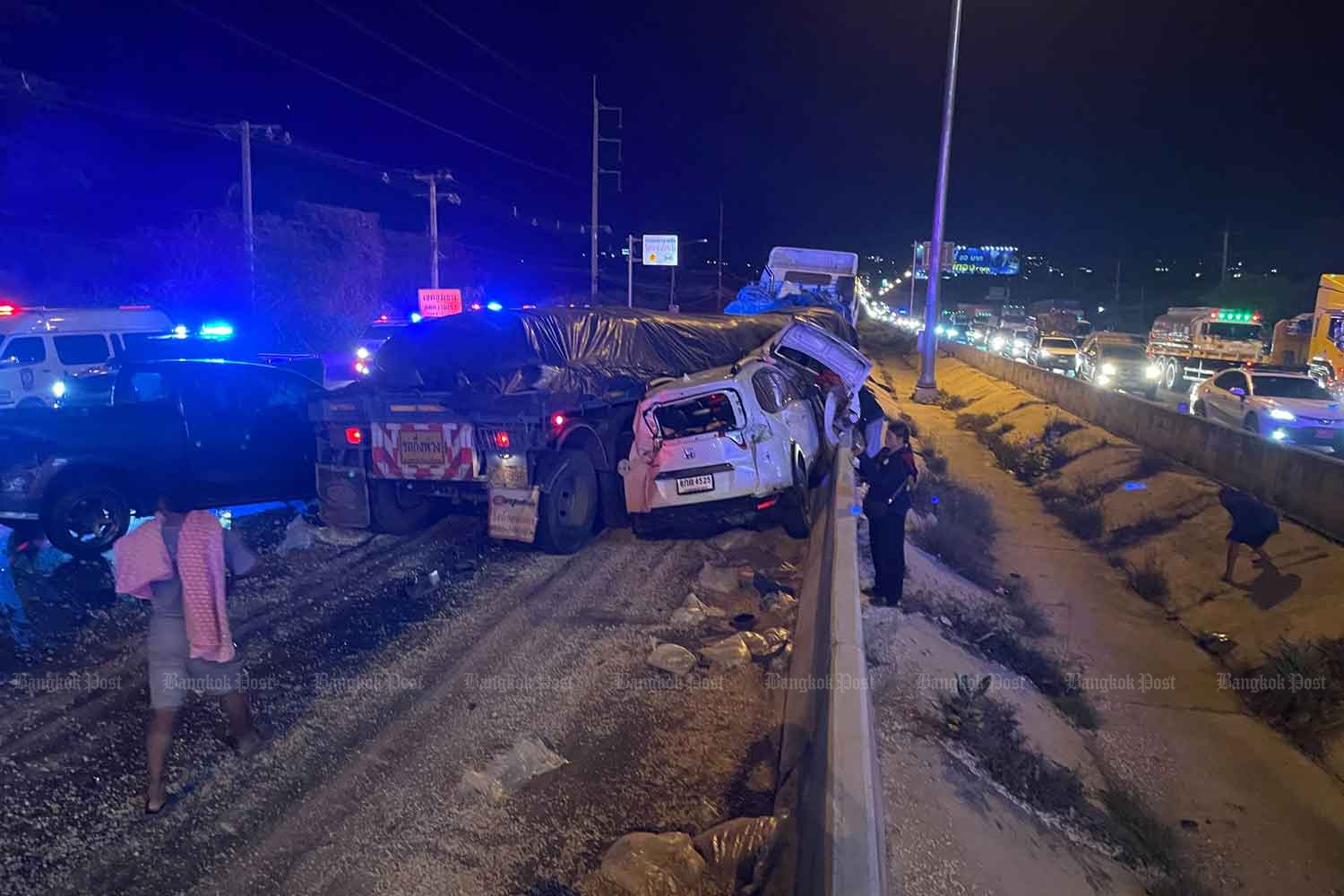 Damaged vehicles block the highway after a trailer truck crashed into them on a downhill slope of the Mitrapap highway in Nakhon Ratchasima's Pak Chong district on Sunday night. Fifteen other vehicles were damaged, one person killed and six others injured. (Photo: Koophai Klangdong)