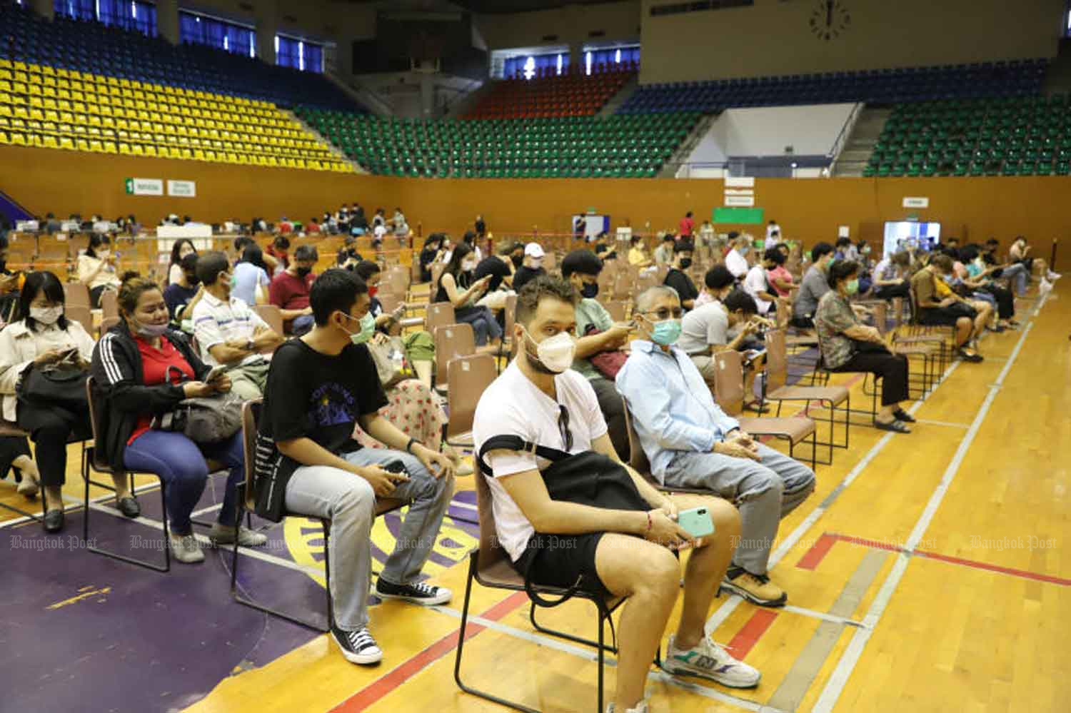 People wait for a Covid-19 shot at a vaccination centre managed by City Hall at the Thai-Japanese Youth Centre in Bangkok's Din Daeng district on Jan 8. (Photo: Varuth Hirunyatheb)