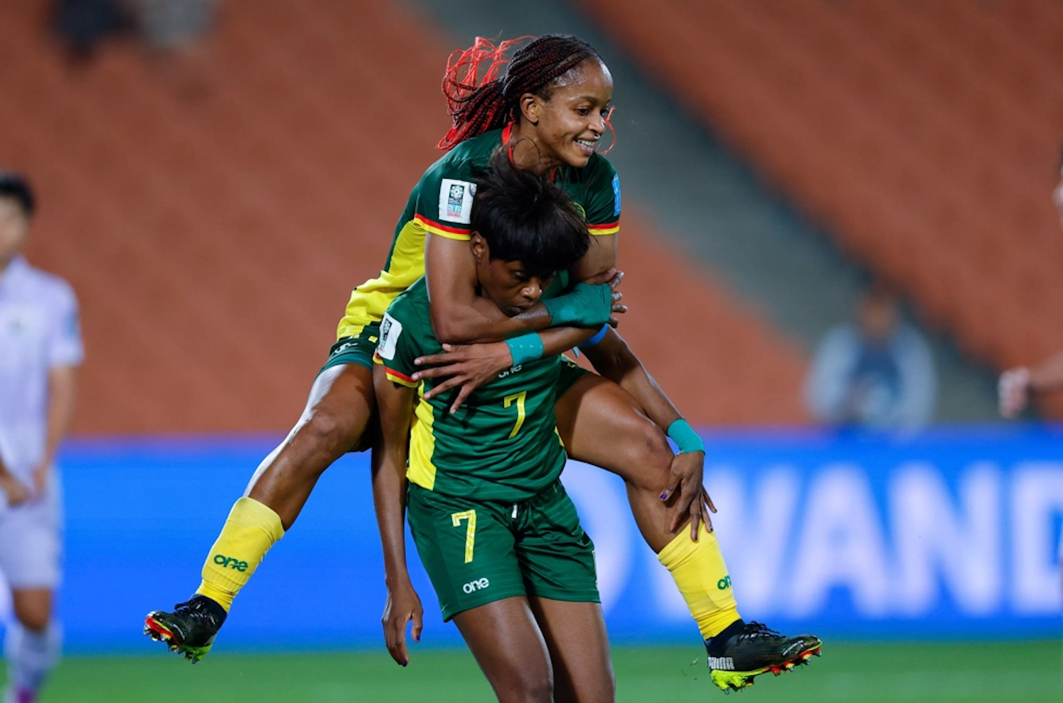 A teammate leaps to celebrate with substitute Gabrielle Onguene (7) after Cameroon’s first goal against Thailand in their Women’s World Cup qualifying playoff at Waikato Stadium in Hamilton, New Zealand on Saturday. (Photo: Fifa)