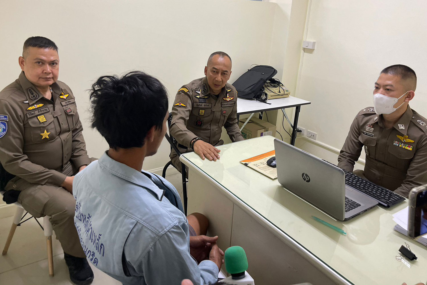 Deputy national police chief Pol Gen Torsak Sukwimol, centre, and investigators interrogate one of four scam suspects arrested in four separate provinces. (Photo supplied/Wassayos Ngamkham)