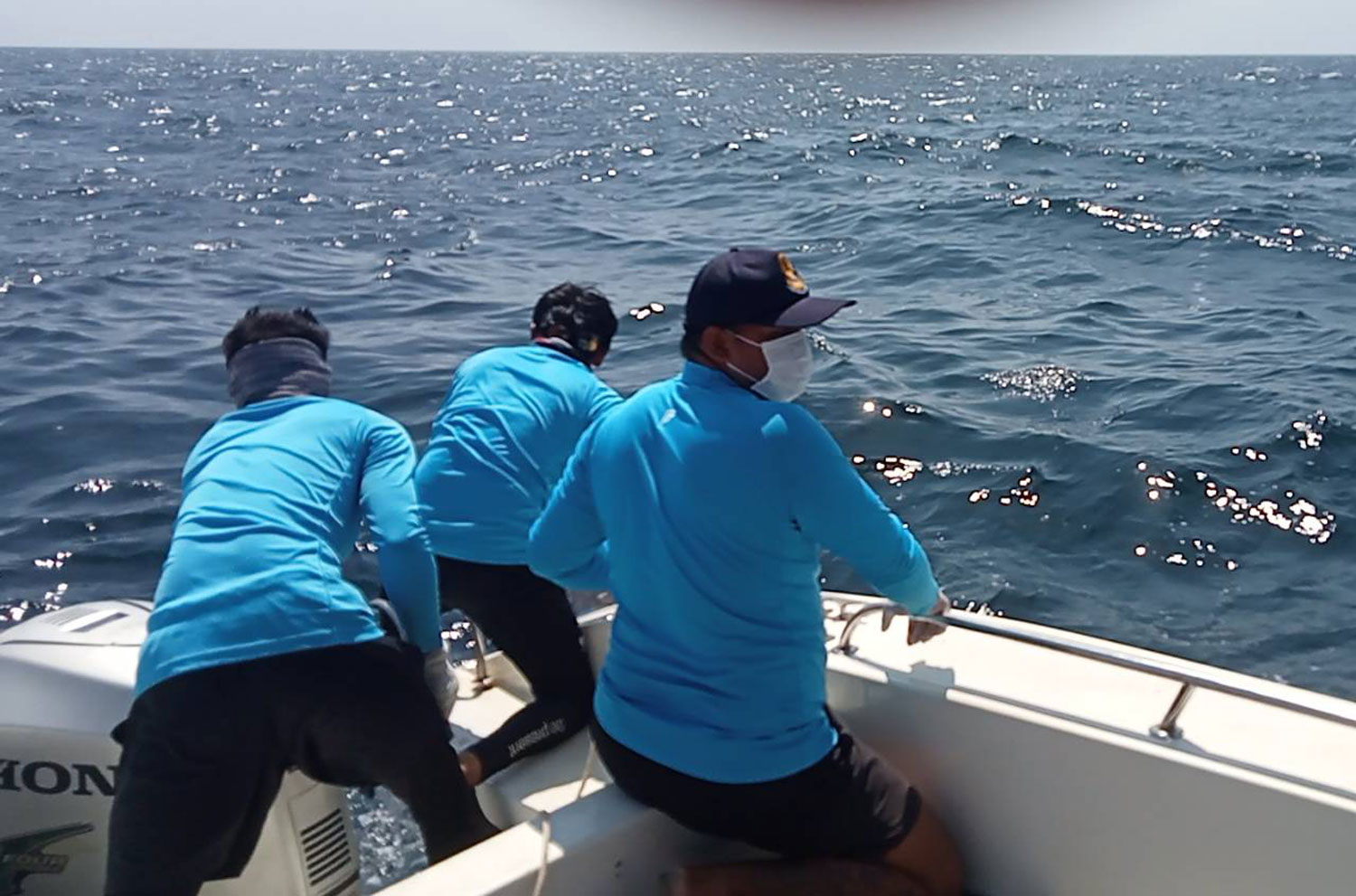 Searchers prepare to take the body found floating off Koh Kaew Nok in Phuket to shore on Friday. (Photo: Achadthaya Chuenniran)