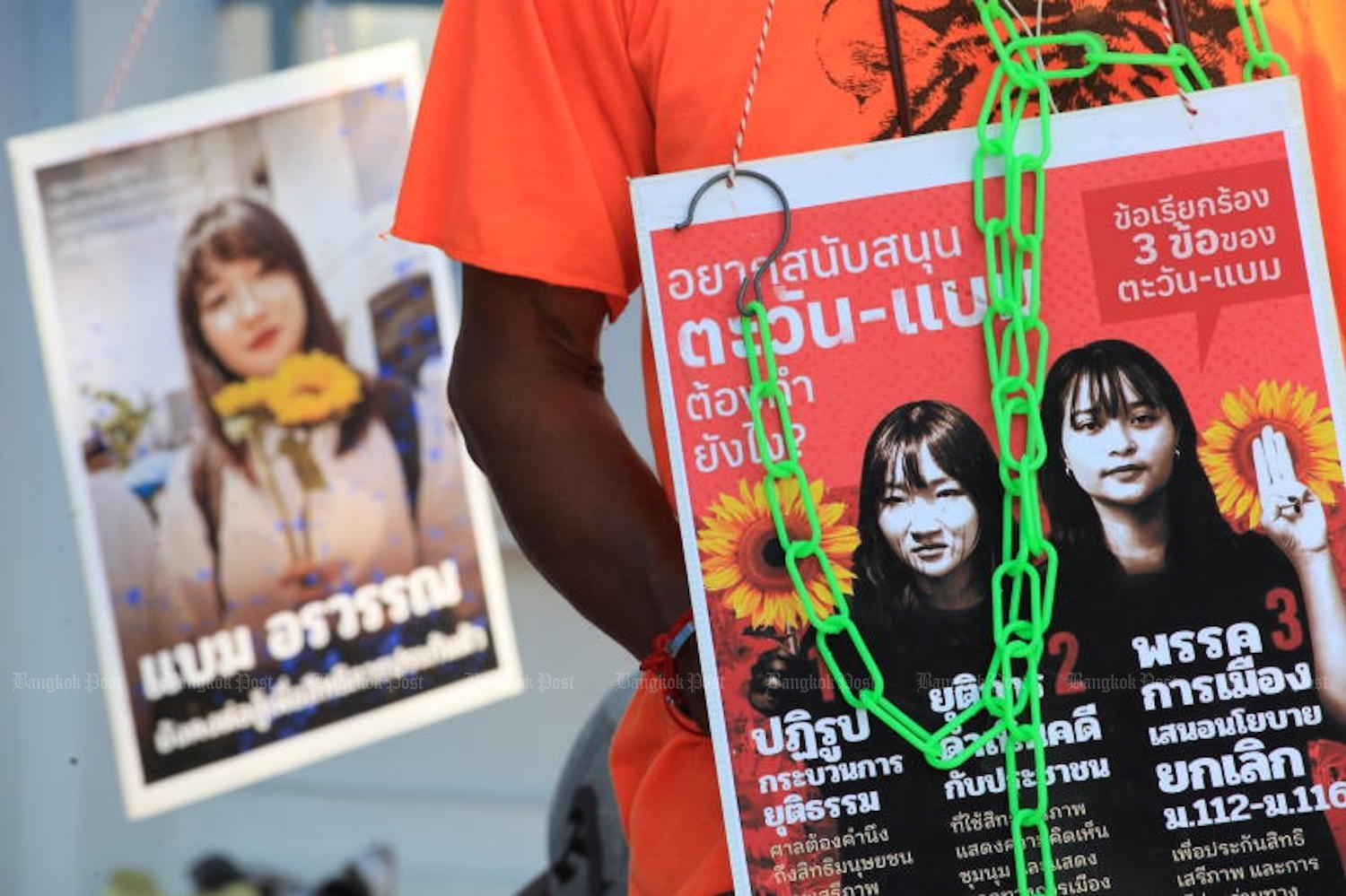 An activist holds a poster featuring protesters Tantawan Tuatulanon and Orawan Phuphong outside the Supreme Court, where the pair staged their fast for from Feb 24 to March 3 before being readmitted to hospital. (Photo: Apichart Jinakul)