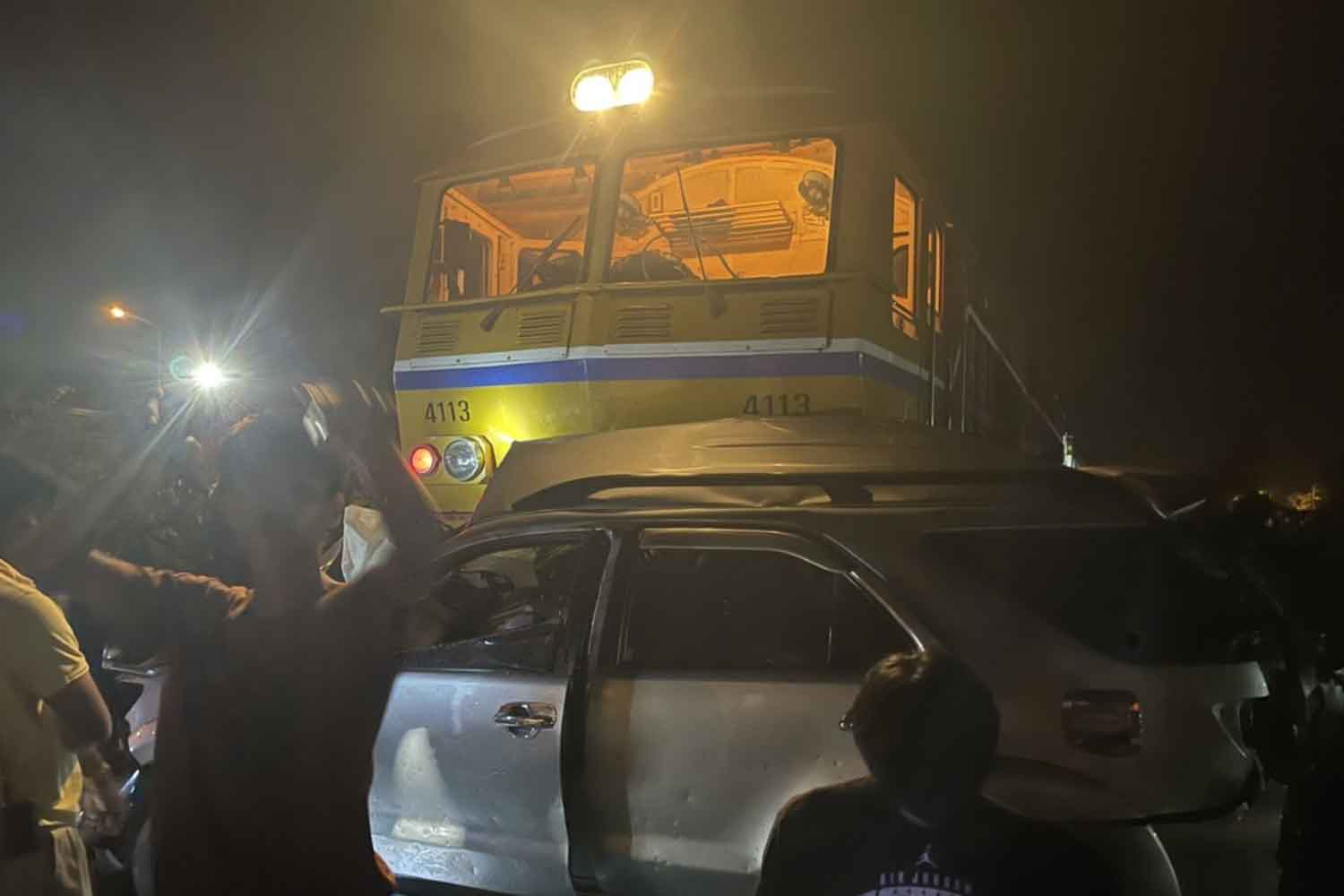 The Toyota Fortuner rests jammed up against the front of the locomotive after being hit by a Trang-Bangkok express train at a railway crossing in Ban Nasan district, Surat Thani, on Monday night. The municipal mayor who was driving it was killed. (Photo: Supapong Chaolan)