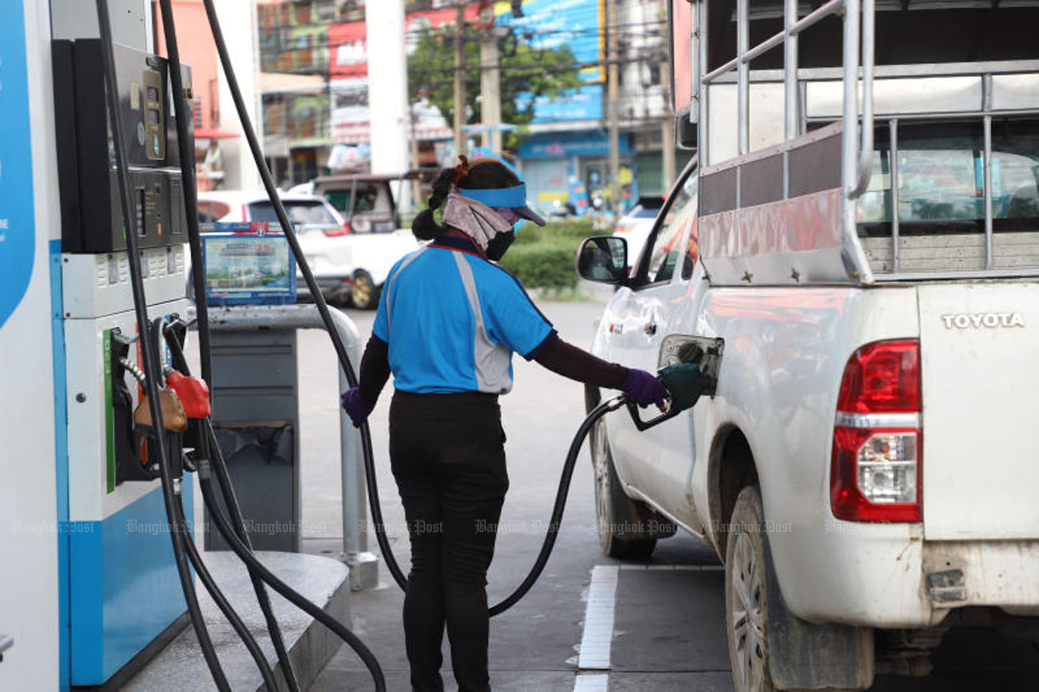 An attendant at a PTT petrol station on Navamin Road in Bangkok’s Bung Kum district fills up a pick-up truck with diesel. (Bangkok Post file photo)